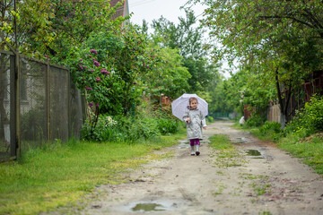 Fototapeta premium summer walk in the rain little girl with an umbrella