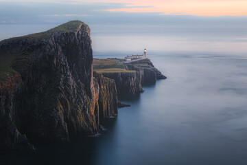 Moody, atmospheric idyllic coastal seascape headland peninsula of Neist Point Lighthouse at sunset...