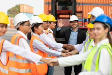 Obraz na płótnie Canvas warehouse boss engineer with factory workers raise hand and shaking hands together for congratulations in containers warehouse storage