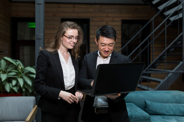Two female employees and male manager explaining business with laptop