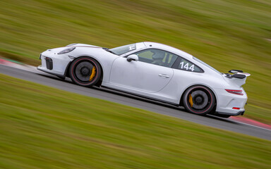 A panning shot of a racing car as it circuits a track.