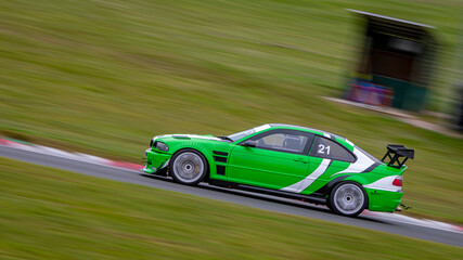 A panning shot of a racing car as it circuits a track.