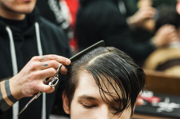 Hipster client man visiting in barber shop shaving hair. Modern guy having his hair cut in barbershop.