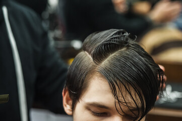 Fototapeta premium Hipster client man visiting in barber shop shaving hair. Modern guy having his hair cut in barbershop.