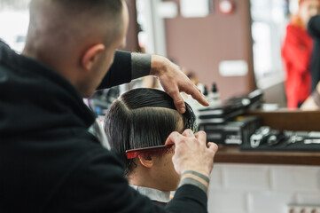 A man in a barbershop.Modern guy having his hair cut in barbershop