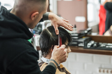 Obraz na płótnie Canvas A man in a barbershop.Modern guy having his hair cut in barbershop