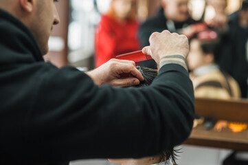 A man in a barbershop.Modern guy having his hair cut in barbershop