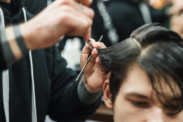 Obraz na płótnie Canvas A man in a barbershop.Modern guy having his hair cut in barbershop
