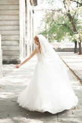 Beautiful bride spinning with perfect dress in the park