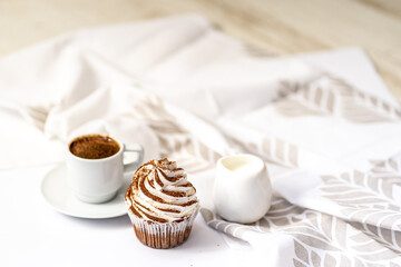 Black coffee with cupcakes and muffins. Spice cupcakes with creamcheese frosting decorated with a cocoa