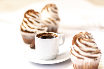 Black coffee with cupcakes and muffins. Spice cupcakes with creamcheese frosting decorated with a cocoa