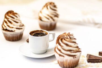 Black coffee with cupcakes and muffins. Spice cupcakes with creamcheese frosting decorated with a cocoa