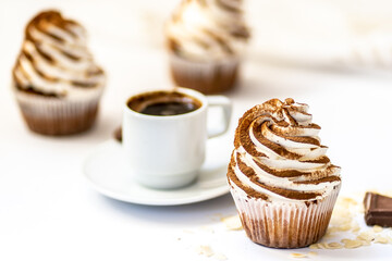 Black coffee with cupcakes and muffins. Spice cupcakes with creamcheese frosting decorated with a cocoa