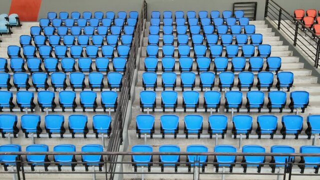 Rows of empty blue stadium seats at sports complex during COVID-19 pandemic