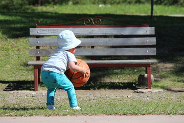little child playing with a basketball