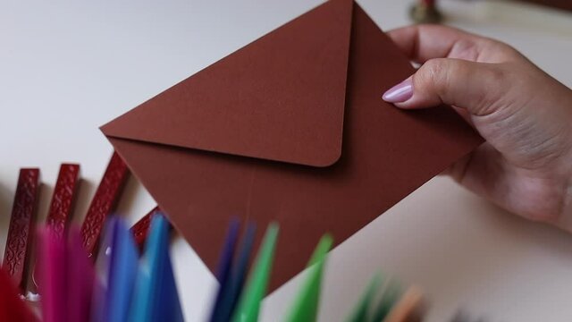 brown envelope in hand on a background of candle and wax for printing