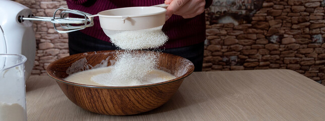 In the bowl, sift the flour through a sieve. The cooking process. Selective focus.
