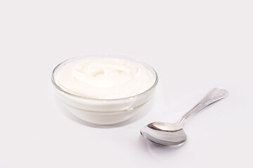 Fototapeta na wymiar sour cream in a plate and spoon, mayonnaise, yogurt isolated on white background