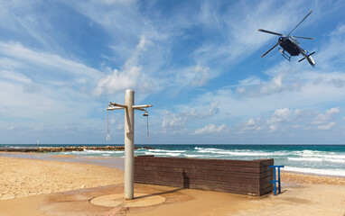 police helicopter flying over the beach