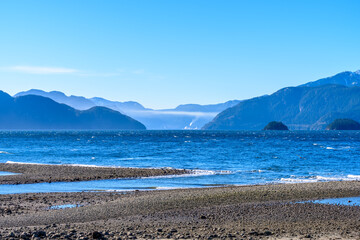 Fototapeta na wymiar Fantastic view over ocean, snow mountain and rocks at Furry Creek Dive Site in Vancouver, Canada.