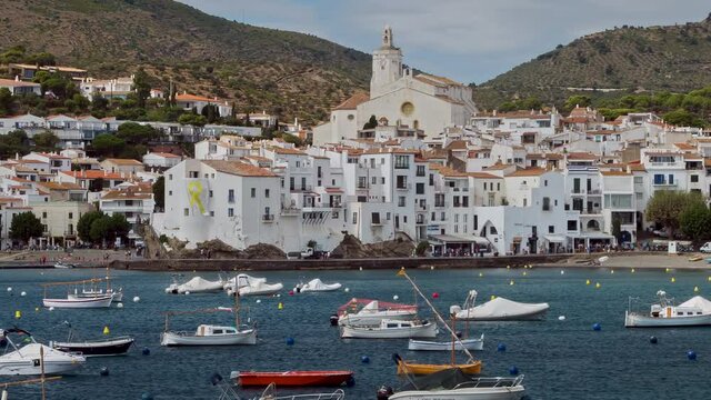 Panoramic view of "CADAQUES".Time lapse.Beautiful tourist coast Spanish village in the shore of Mediterranean sea,with the fast movement of the boats at anchored.Smooth camera movement: Panning Right.