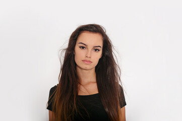 Fototapeta premium Beautiful young woman with brunette hairstyle with no make-up, standing frontal looking at camera over white background.