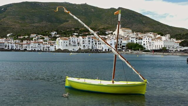 Seascape of the "COSTA BRAVA" in Catalonia, Spain.
Ancient boat fishing with lateen sail anchored in front of tourist coast village of "CADAQUES"