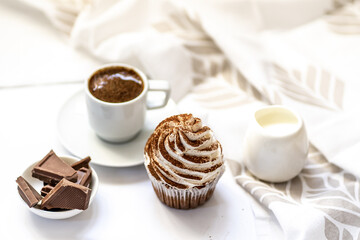 Black coffee with cupcakes and muffins. Spice cupcakes with creamcheese frosting decorated with a cocoa