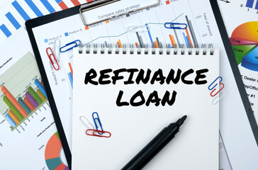 On the table are reports, charts, a notebook with the inscription - REFINANCE LOAN