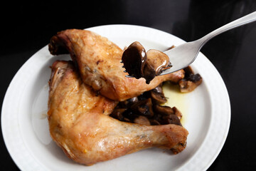 roasted chicken leg served with mushrooms on a plate. Concept homemade food.