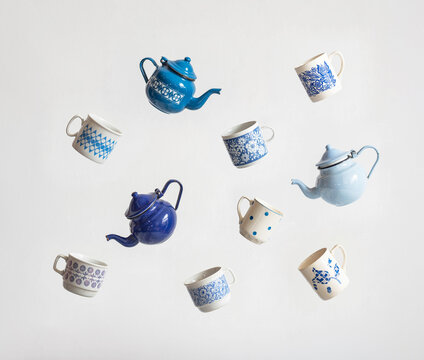 Blue color mid-century modern cups and teapots floating in the air isolated