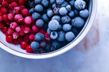 frozen red currants in a half bowl on a light background