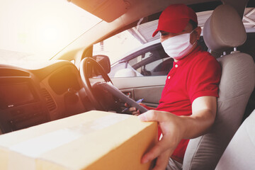 Delivery man employee in red cap t-shirt uniform mask checking preparing packages to deliver to customers who order online during the coronavirus or covid-19.