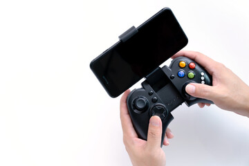 Black gaming joystick with smartphone installed into holder in gamer hands, with blank black...