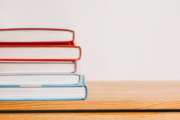A stack of books on wooden table. Mock up with education and reading concept. Literature for...