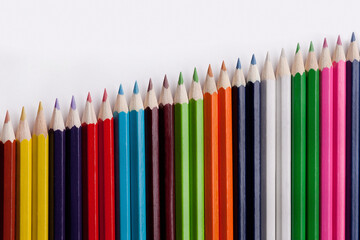 Colored pencils isolated on a white background. Dynamics, growth.