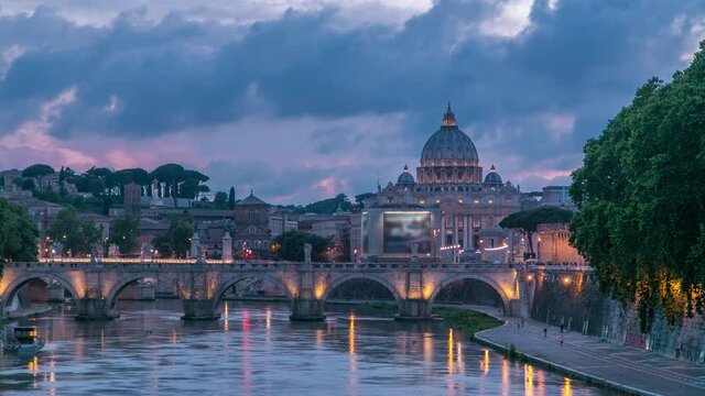 St. Peter's Basilica, Saint Angelo Bridge and Tiber River after the sunset day to night transition timelapse. View from bridge with beautiful cloudy sky. Rome, Italy