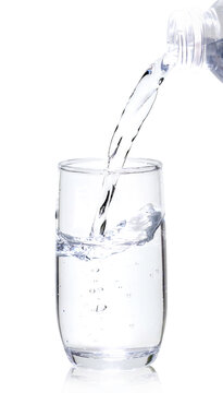 Pouring water from a clear plastic bottle into a glass isolated on white background with clipping path, Suitable for design