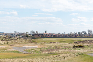 Obraz premium Looking accross the Prestwick Golf course greens to the town of Prestwick on a cold April Day