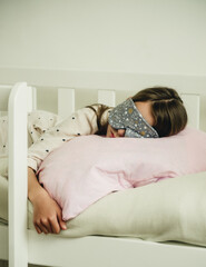 Obraz na płótnie Canvas teenage girl in a mask for sleeping in the bed