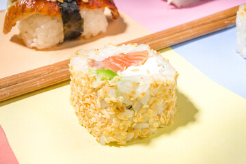 Sushi rolls set with rice and fish and chopsticks on various colorful bright backgrounds, trendy dark shadows flatlay
