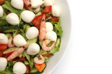 Fresh summer salad with shrimp, cucumber, tomato, lettuce and mozzarella in bowl