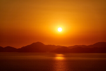 A picturesque view of the warm sea sunset and the mountainous coast