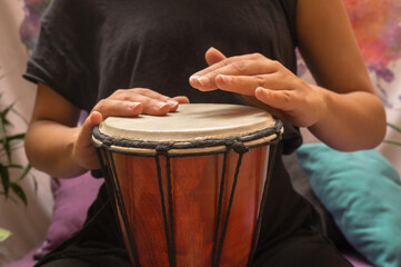 Closeup to woman's hands playing the drum. African djembe