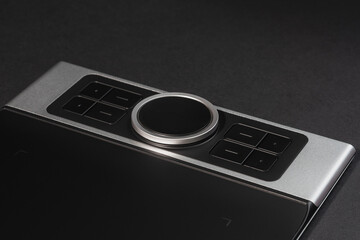 Round Dial Studio edit device with buttons on dark background.