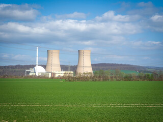 Fototapeta na wymiar nuclear power plant against sky and green grass