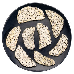 slices of dried white dragon fruit (pitaya) on an isolated black ceramic plate