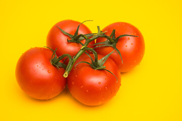 Red ripe tomatoes on a yellow background. Preparing a salad of vegetables. Natural products from the beds.