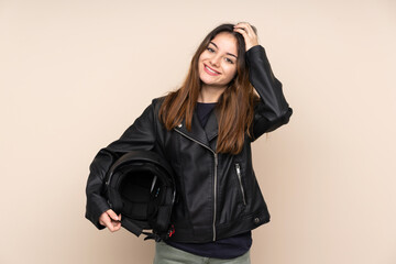 Woman with a motorcycle helmet isolated on beige background laughing