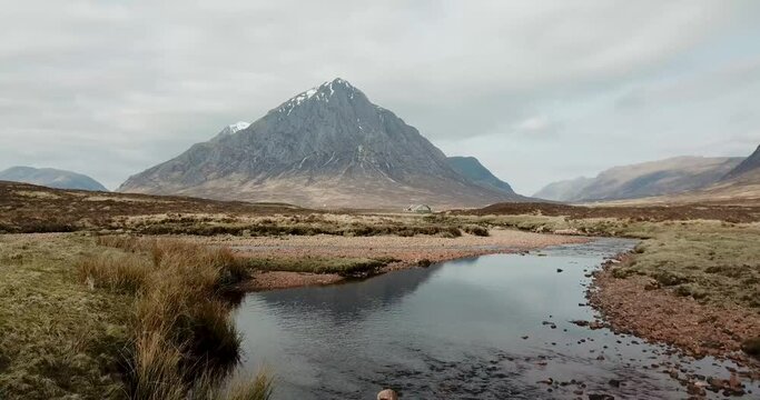 4k aerial footage of Buachaille Etive Mor mountain, River Coe, and A82 road. Scottish Highlands, UK.
